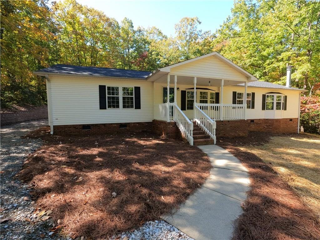 The 3 BR, 2-1.2 baths home, with driveway on the left accessing the rear of the home with a double carport, attached double garage and two sheds that convey!