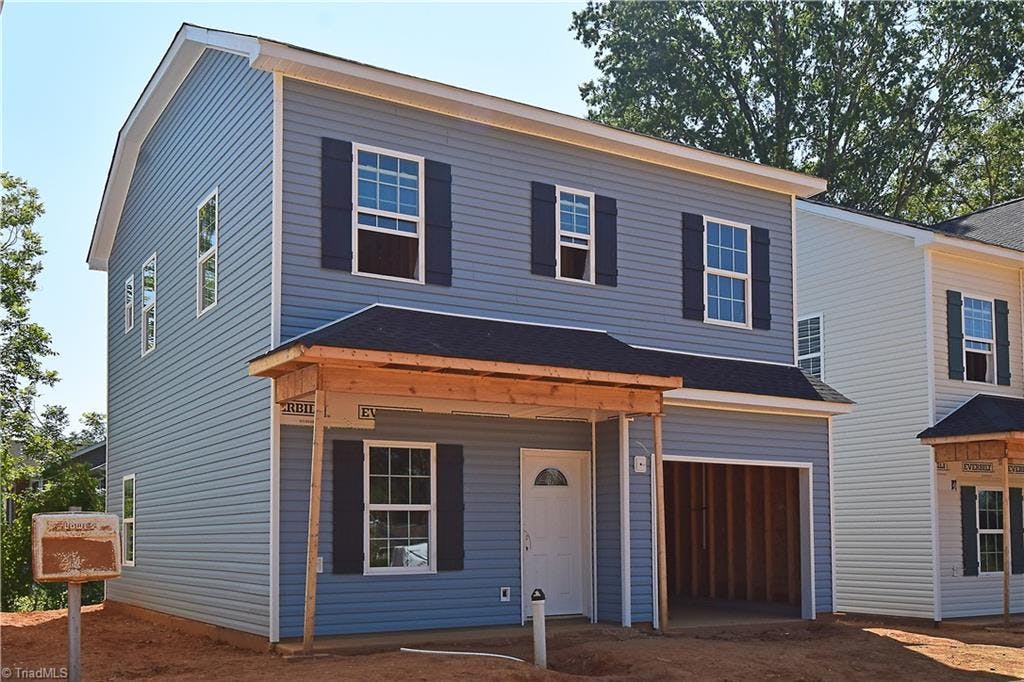 This handsome transitional is clad in vinyl siding and features a covered front porch.